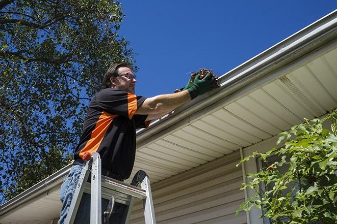 worker installing new gutter system on a roof in Anaheim, CA